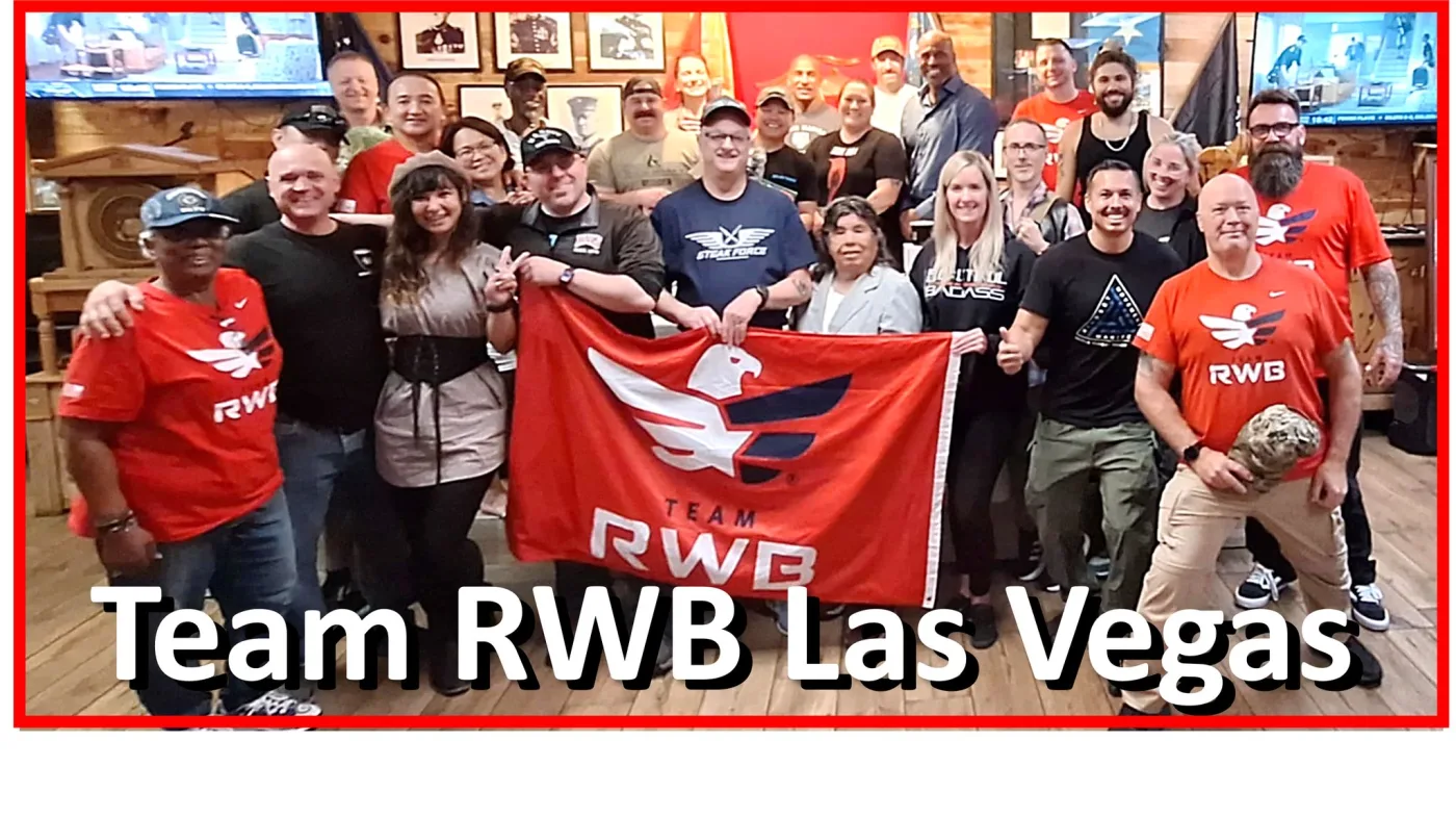 Group photo of more than two dozen Team RWB Las Vegas members posing with the Team Red, White and Blue flag at the Leatherneck Club.