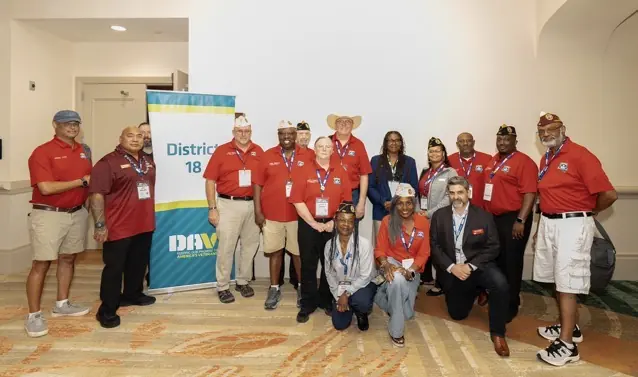 Convention attendees gather behind their DAV District 18 banner.