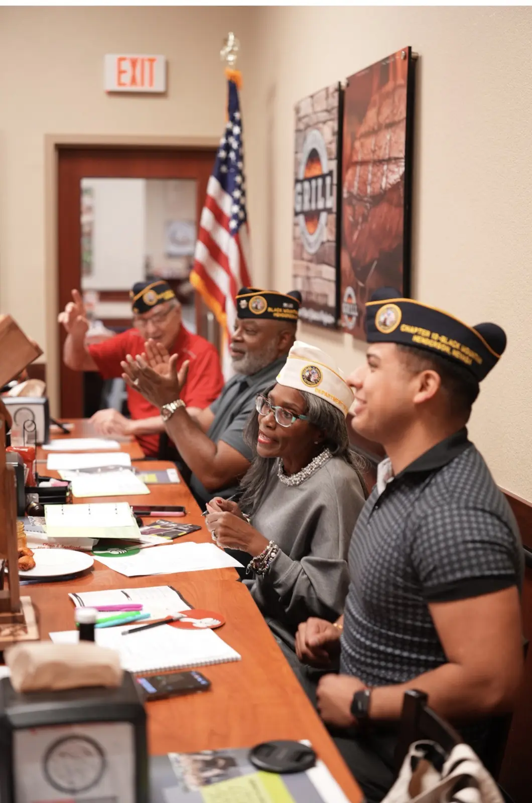 Officers in DAV garrison caps sit along the head table beside the American flag.