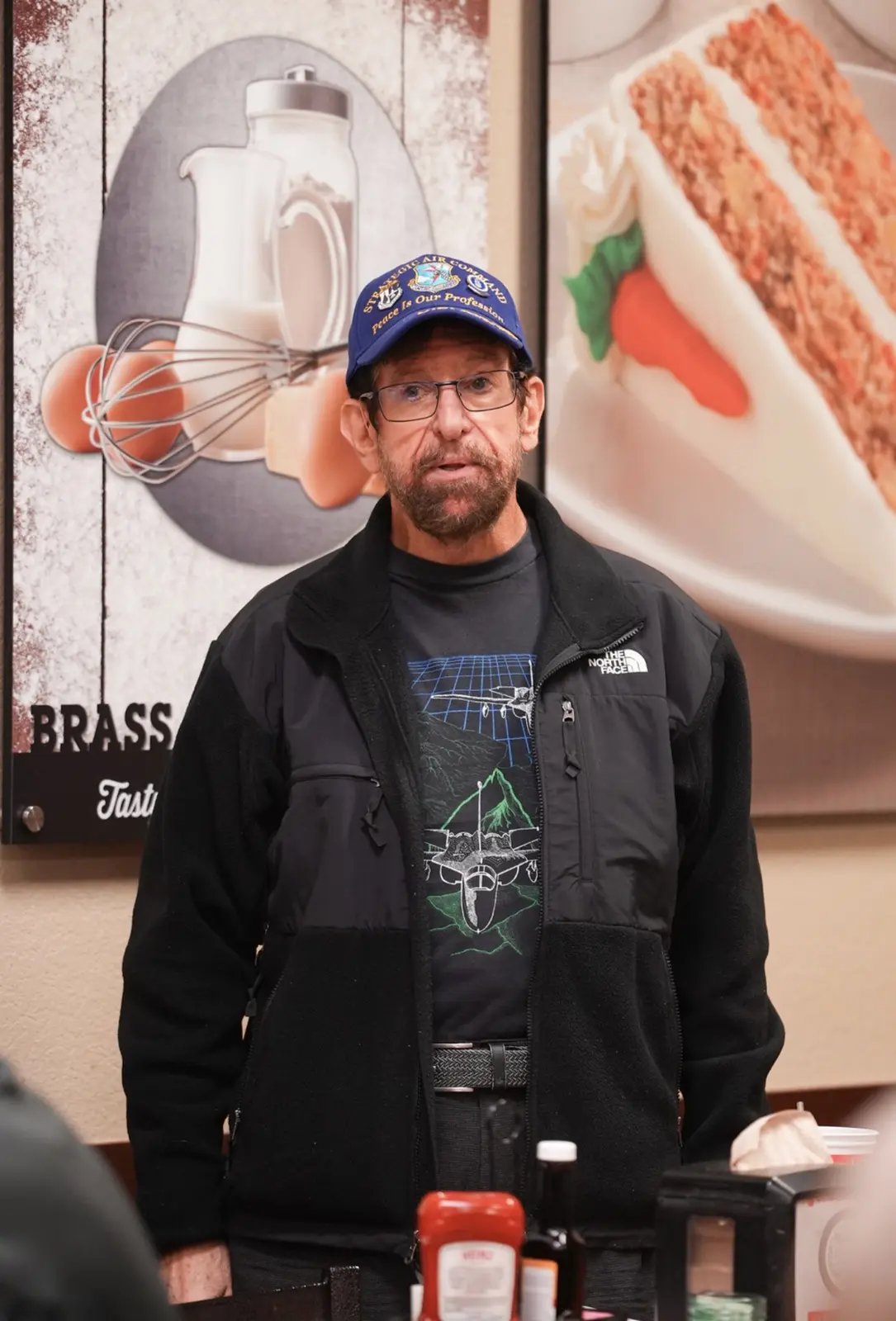 A member in a blue cap and black jacket stands to speak to the Chapter.