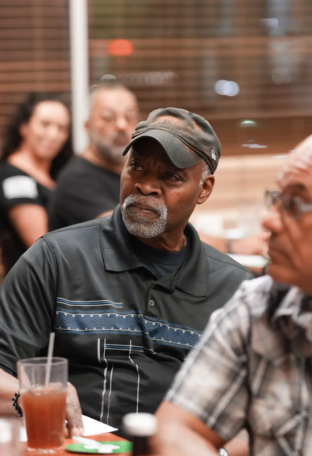 A Veteran in a cap listens closely to the discussion.