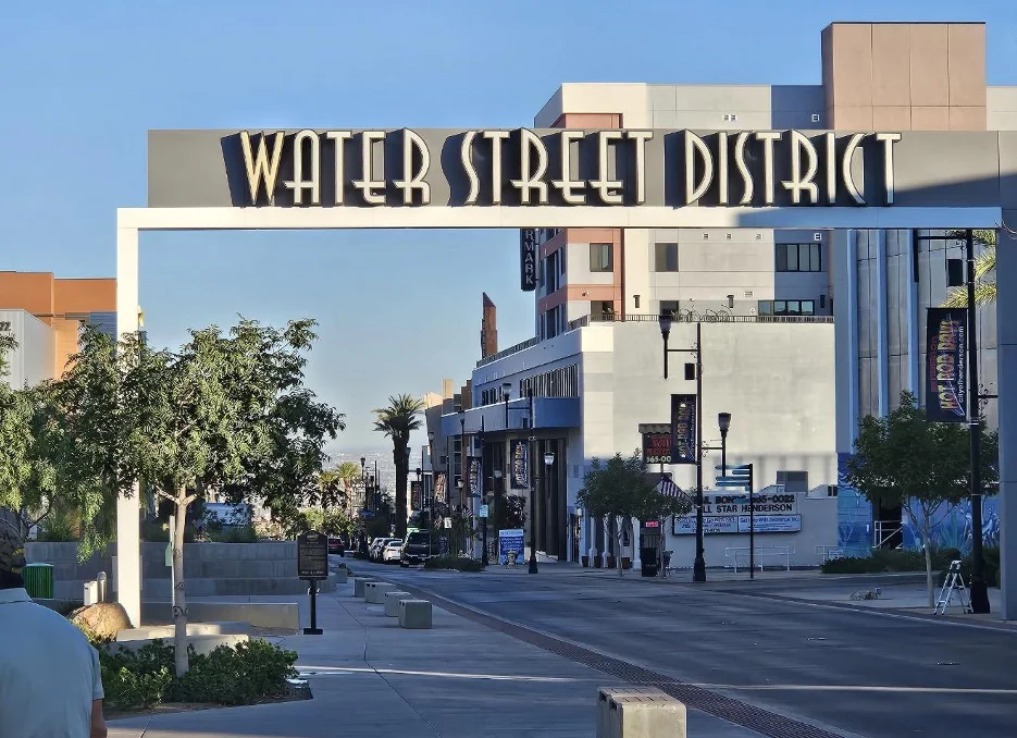 The Water Street District sign arches over Water Street in downtown Henderson on a clear morning.